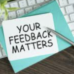 Your feedback matters on a sticky note with a pen and computer keypad.